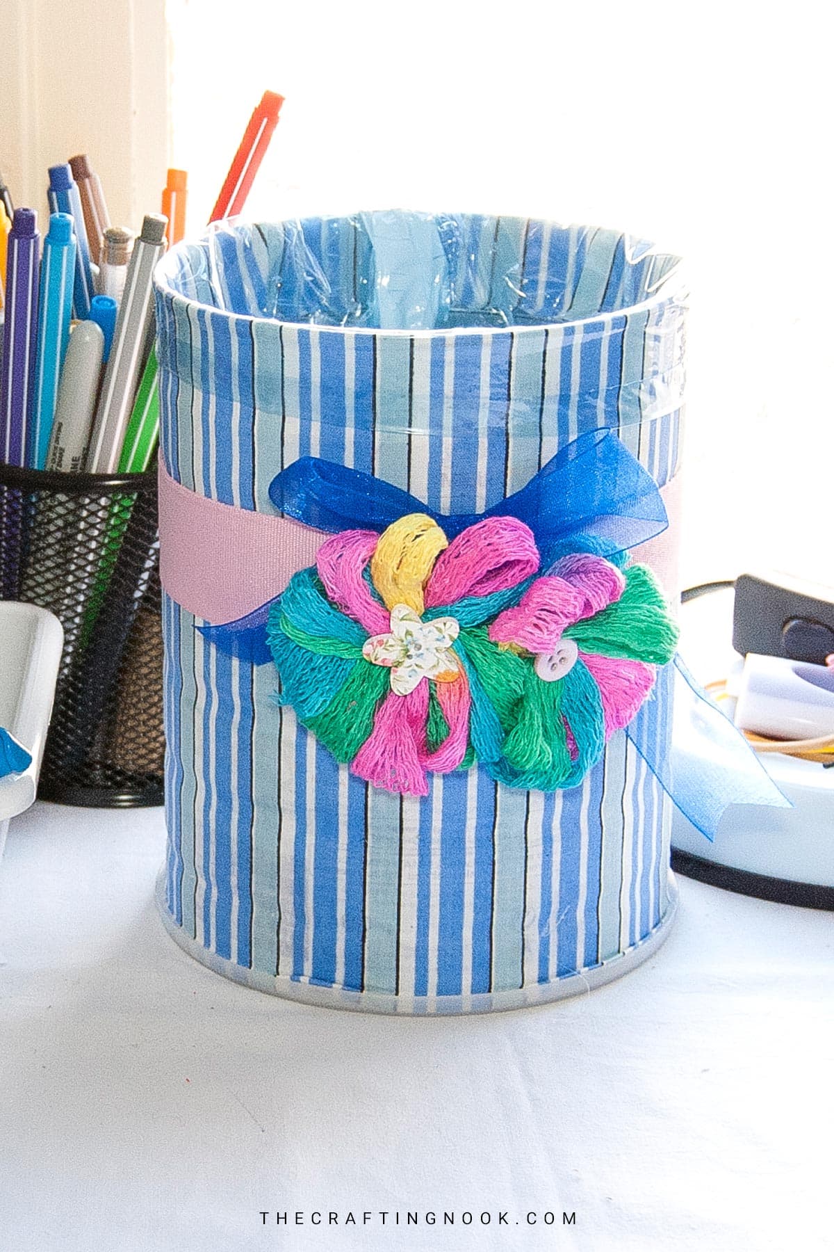 DIY Upcycled Tin Can Trash Can decoupage with blue stripped fabric and a pink decorative ribbon Cover image