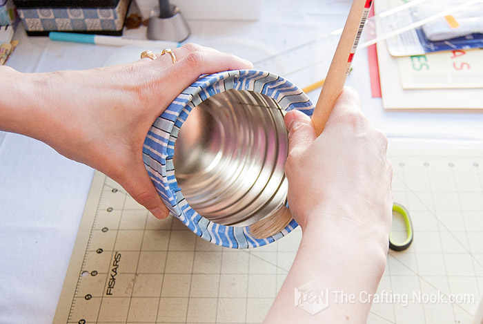 folding the fabric inside the can and applying glue with a brush
