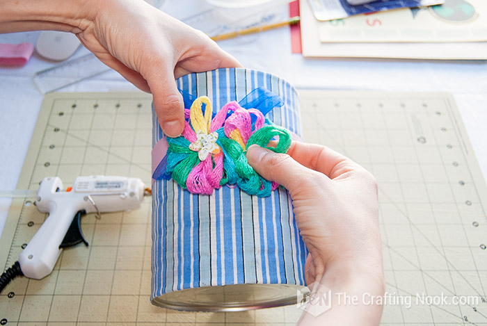 placing fabric flowers on the pink ribbon
