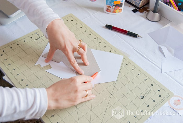 view of cutting the shape of the pattern in the white cardboard