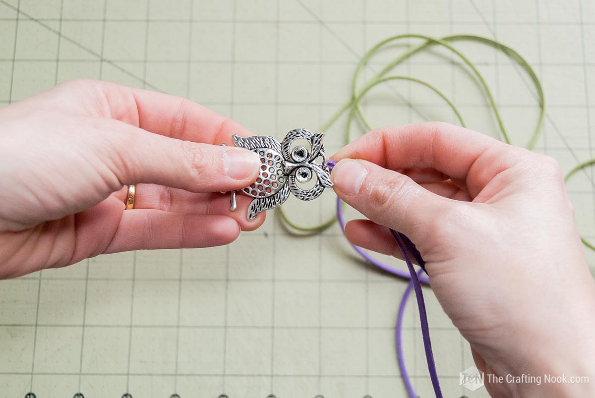 inserting the folded end through the hole in the Owl Charm, from back to front