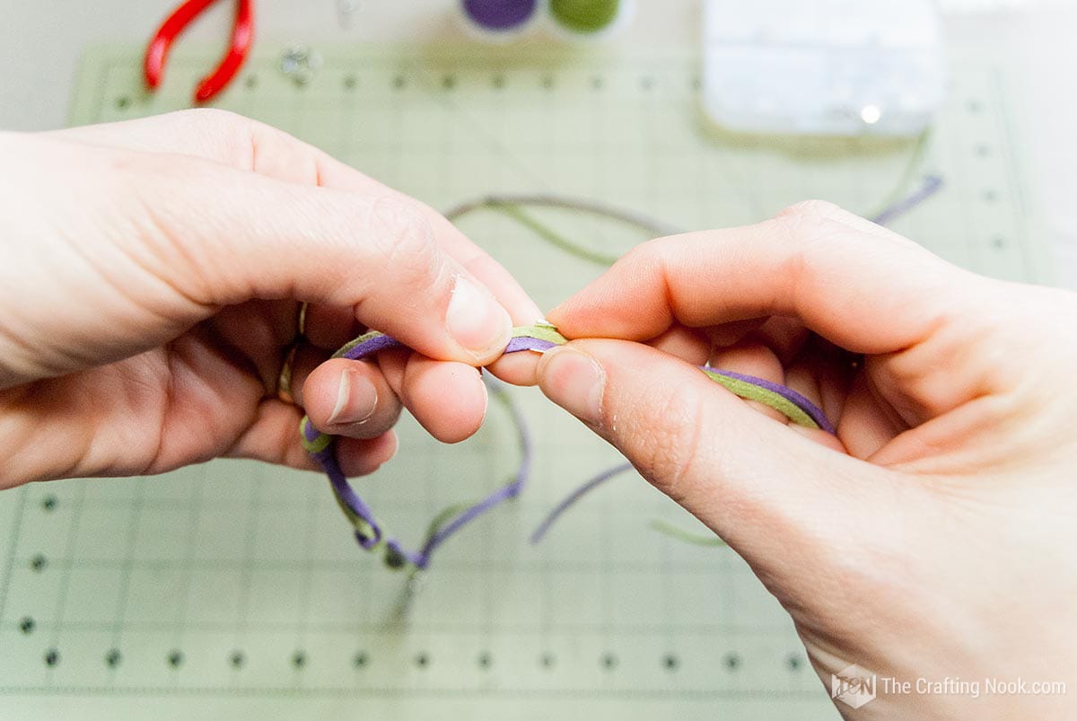 placing the clasp in the mark made on the laces