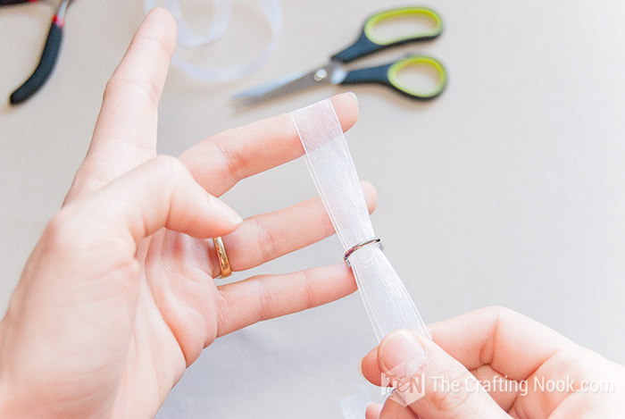 inserting the clasp through the folded ribbon