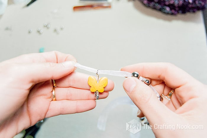 Inserting the end of a string in the jump ring.