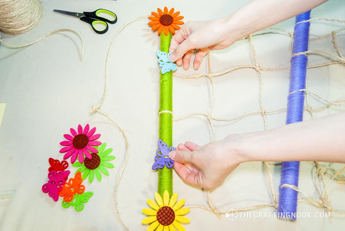 placing multicolored felt flowers and butterflies on top of the hair clips holder