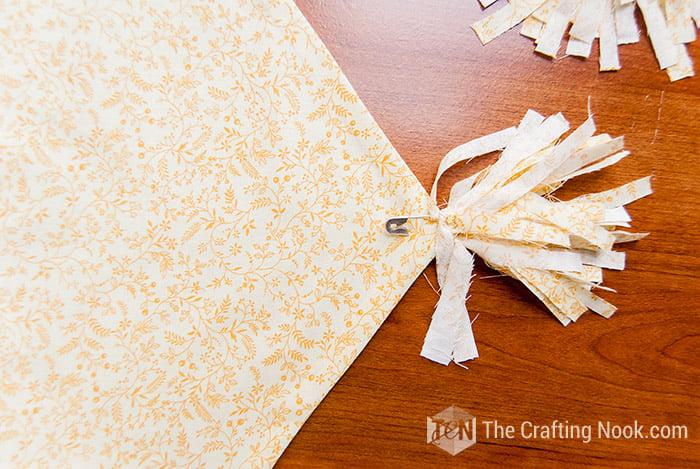 view of applied the safety pins to both ends of the table runner