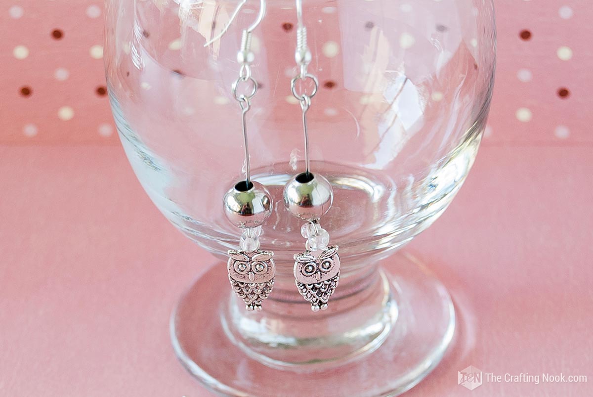 owl earrings on a glass goblet ready