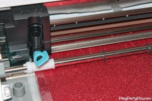 Silhouette cameo fall burlap banner Silhouette cutting machine cutting red glitter cardstock letters for the DIY fall banner.