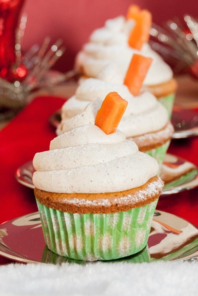 Carrot Cake Cupcakes Recipe ith Cinnamon Buttercream Frosting layed out in line one in front of the other