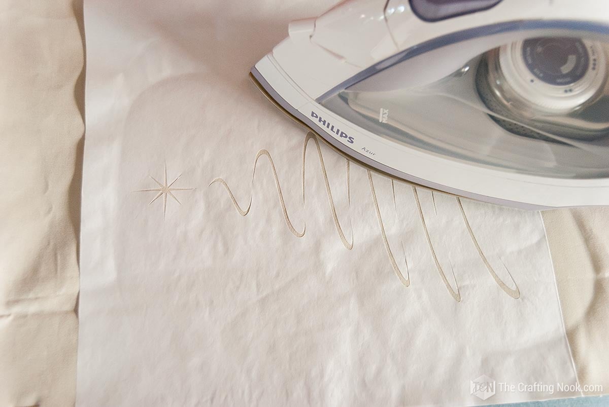 ironing the paper template onto the fabric
