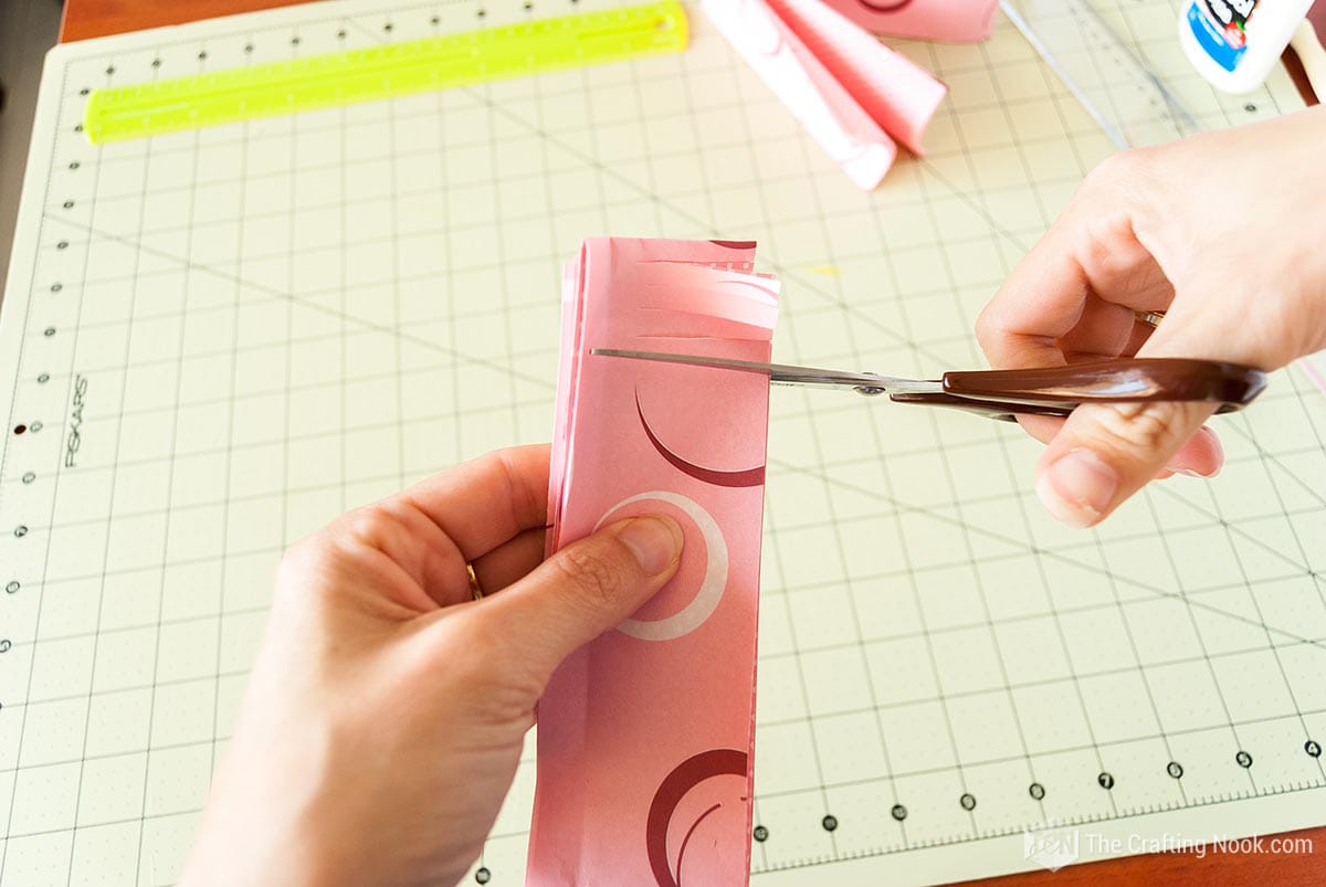 making cuts along the folded paper as if you were making a Hawaiian skirt
