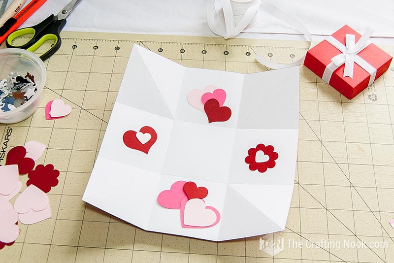 pieces of decorative paper hearts and flowers on the inner side of the open box