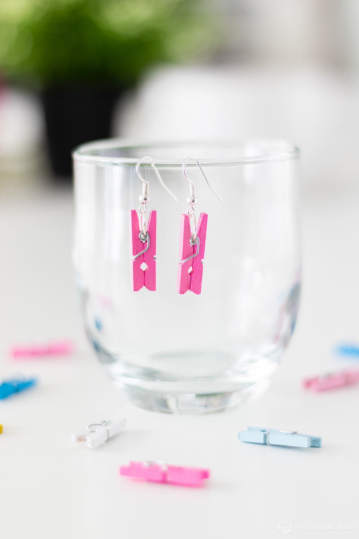 Pink DIY Mini Clothespin Earrings displayed on a glass