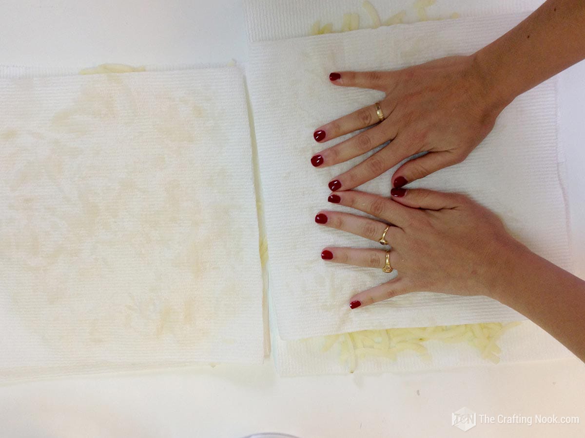 placing a paper towel over grated potatoes to remove moist