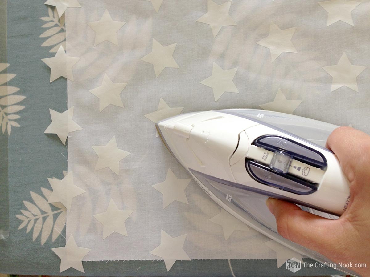 overhead view of me ironing the freezer paper stars onto the fabric