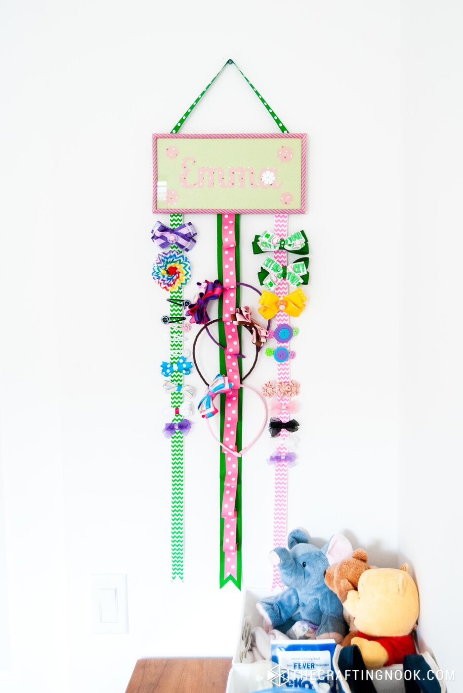 showing DIY Hair Bow Holder hanging on a wall with accessories already placed