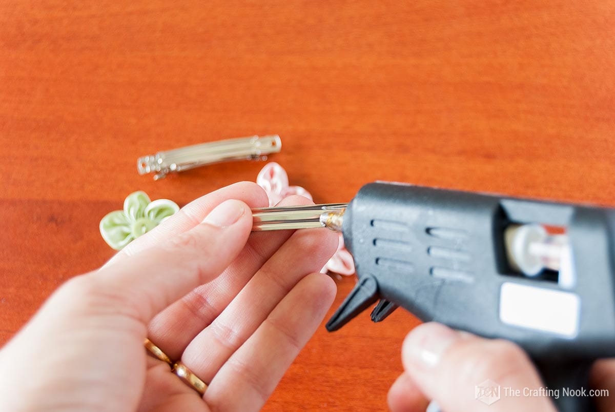 applying hot glue on plain hair clip