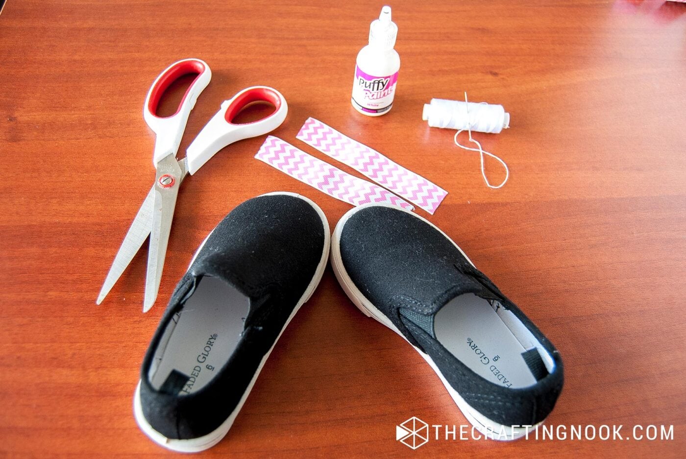 view of Pair of plain shoes, chevron ribbon, scissors, pins, thread and needle