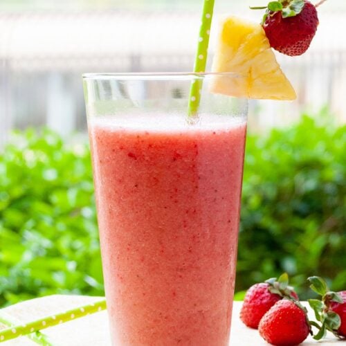 Strawberry Banana Pineapple Smoothie Recipe cover image, decorated with pineapple wedges and starwberry on a table