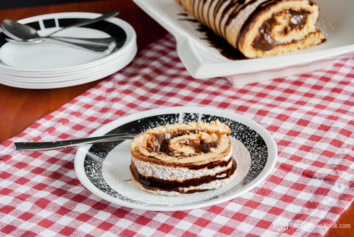 Slightly overhead view of a slice of the Vanilla Roll Cake with Chocolate Filling Brazilian Brigadeiro on a plate