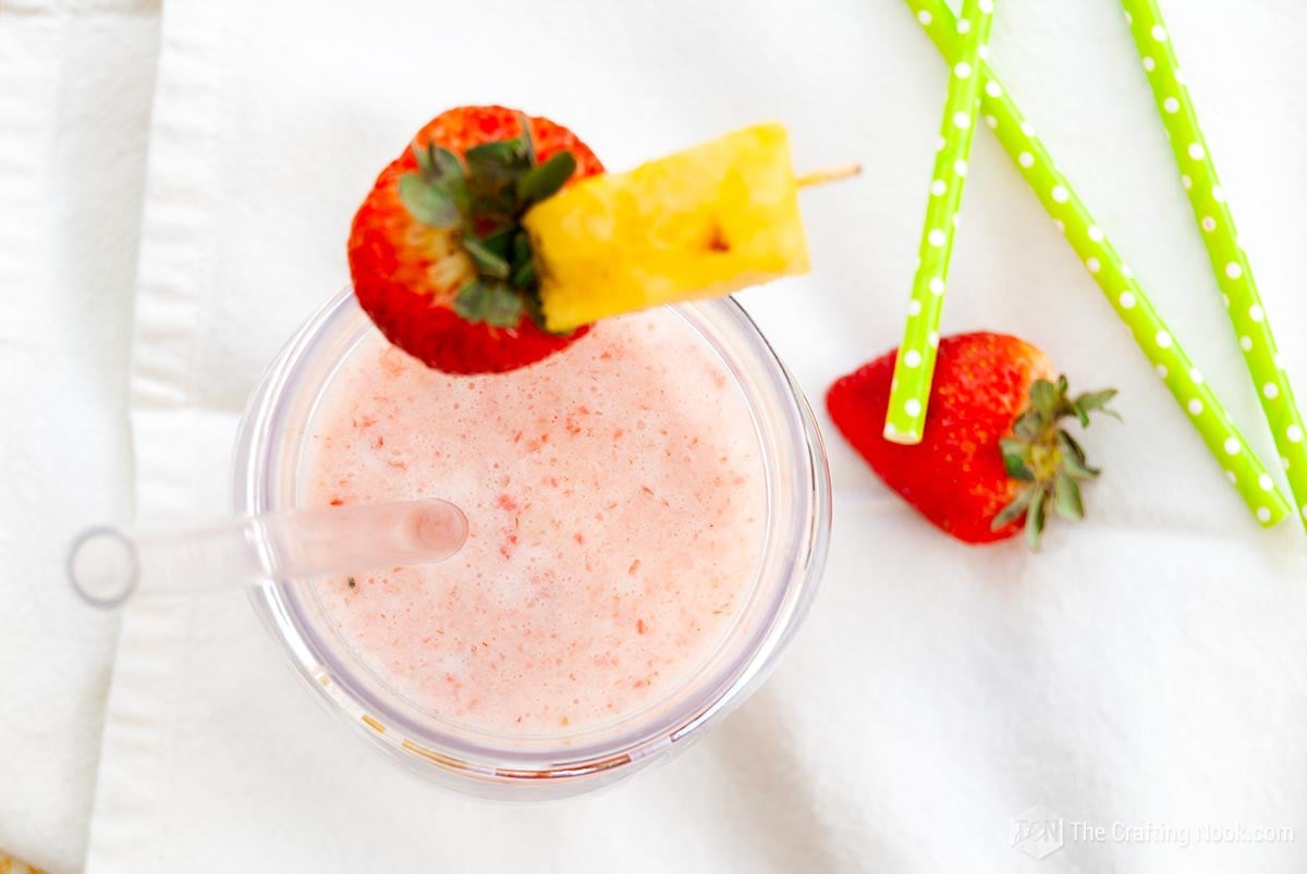 Overhead view of the Strawberry Pina Colada garnished with A strawberry and a pineapple wedge