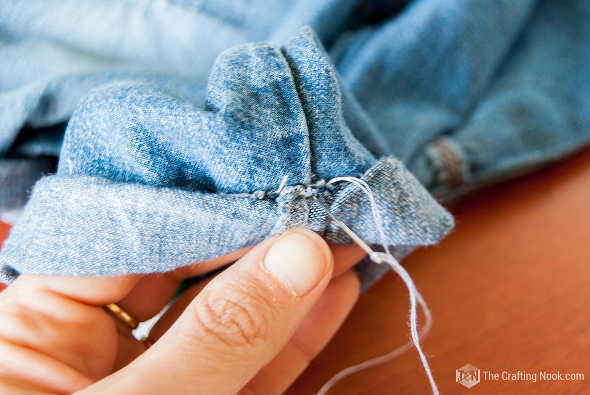 closeup of needle inside the pants to make the fold
