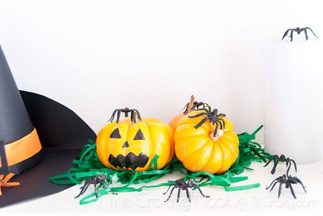 pumpkins with eyes and mouths drawn on strips of green wrapping paper