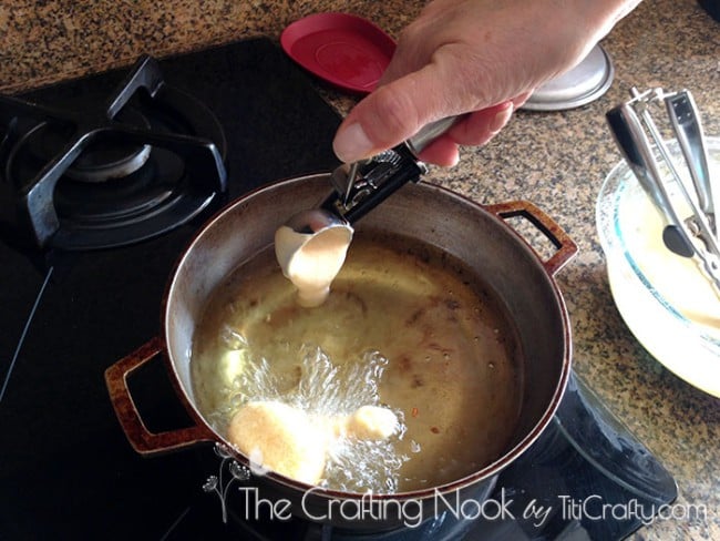 placing the mixture with an ice cream scoop in a pot with hot oil