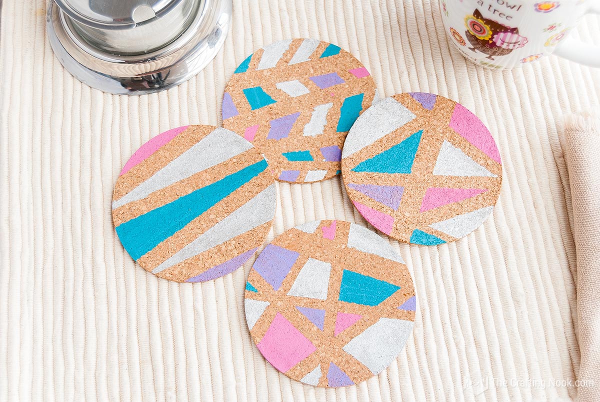 Overhead view of the 4 Geometric Painted Cork Coasters forming a square