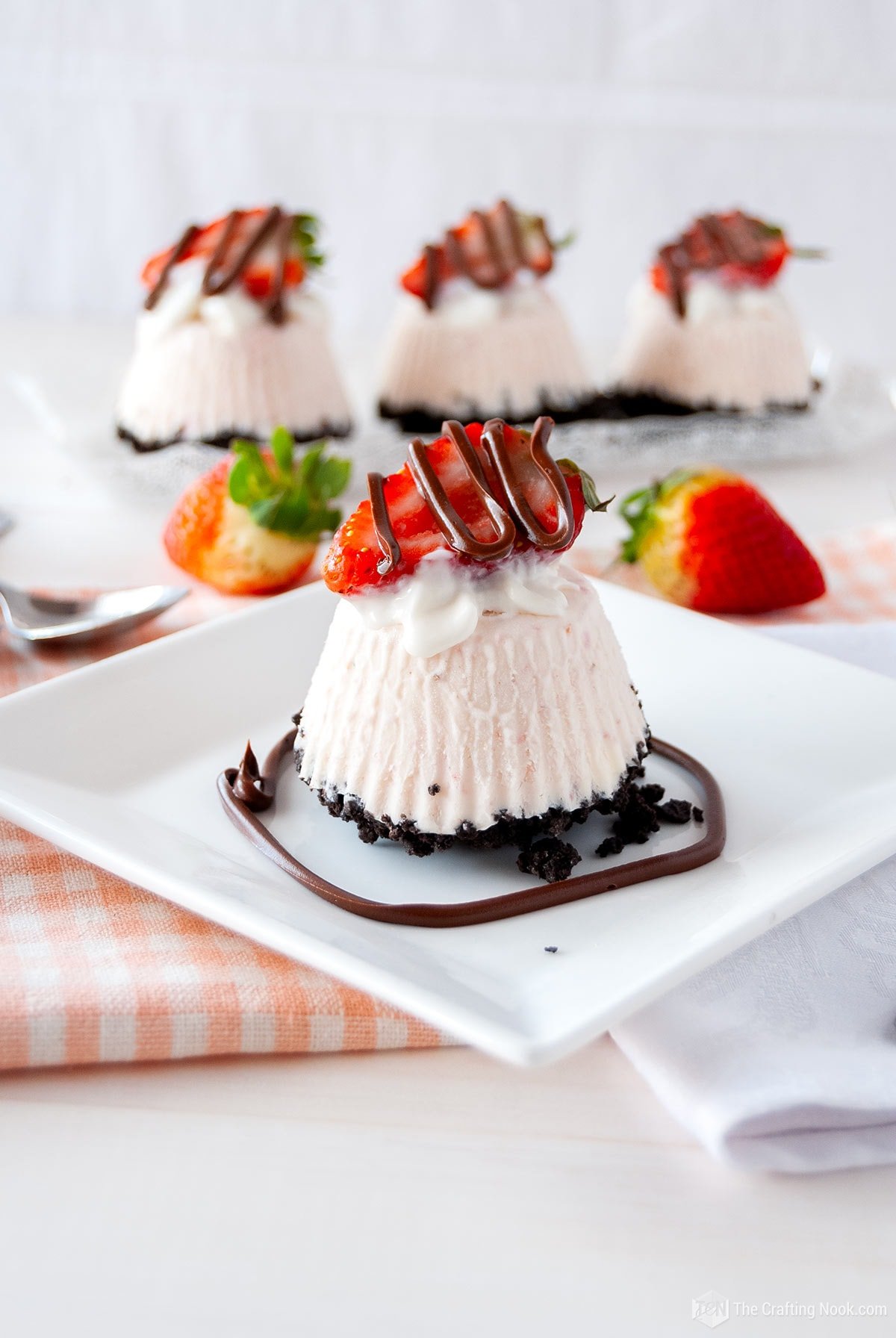 A more open shot of one Individual Frozen Oreo Strawberry Pie in front and 3 behind