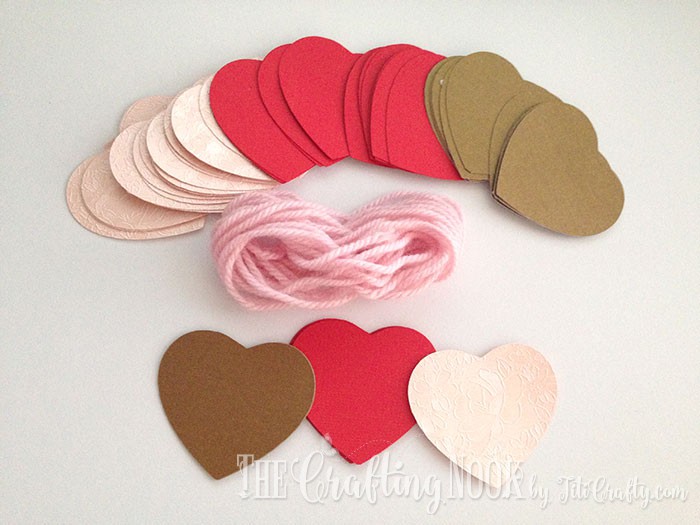 pink, red and gold hearts and pink yarn ready to start assembling the  Paper Heart Garland