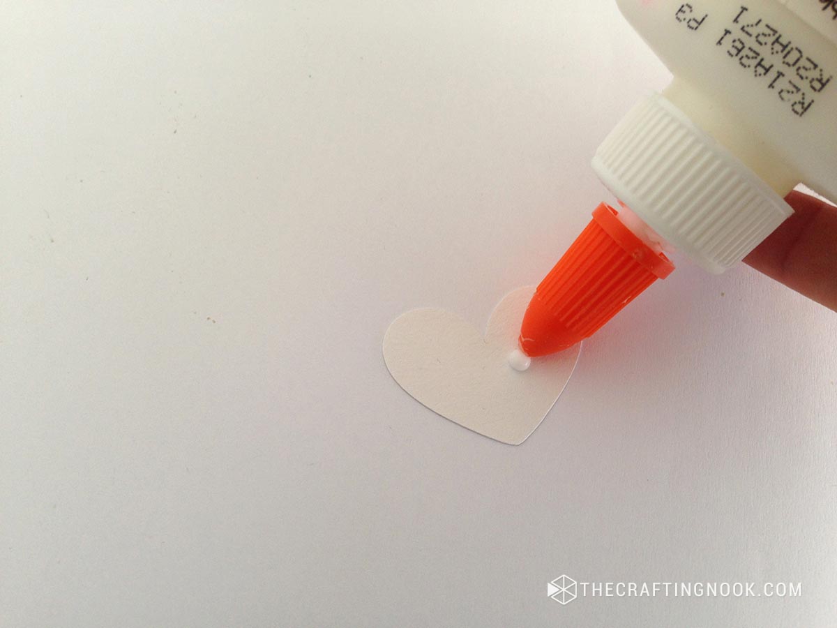 placing white glue on the cut heart