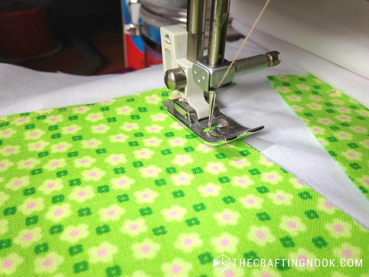 closeup of machine stitching each letter to the white fabric
