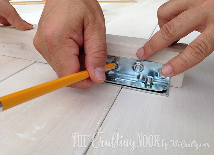 Marking the holes in the metal joints with a pencil
