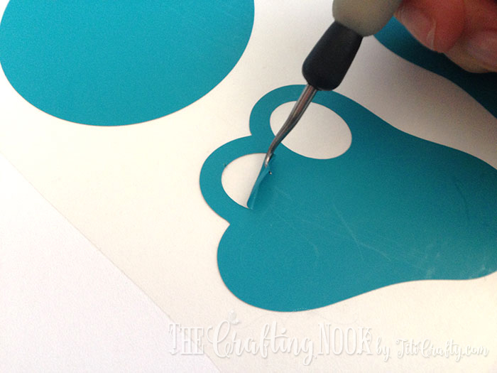 detailed view of the heat transfer vinyl being peeled off with a hook tool