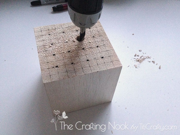 drilling holes in the wooden cube