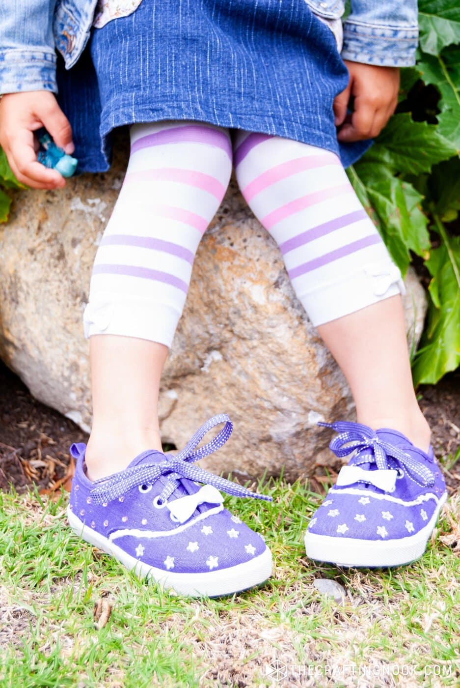 View of legs of girl with DIY Rhinestone Shoes sitting on a rock