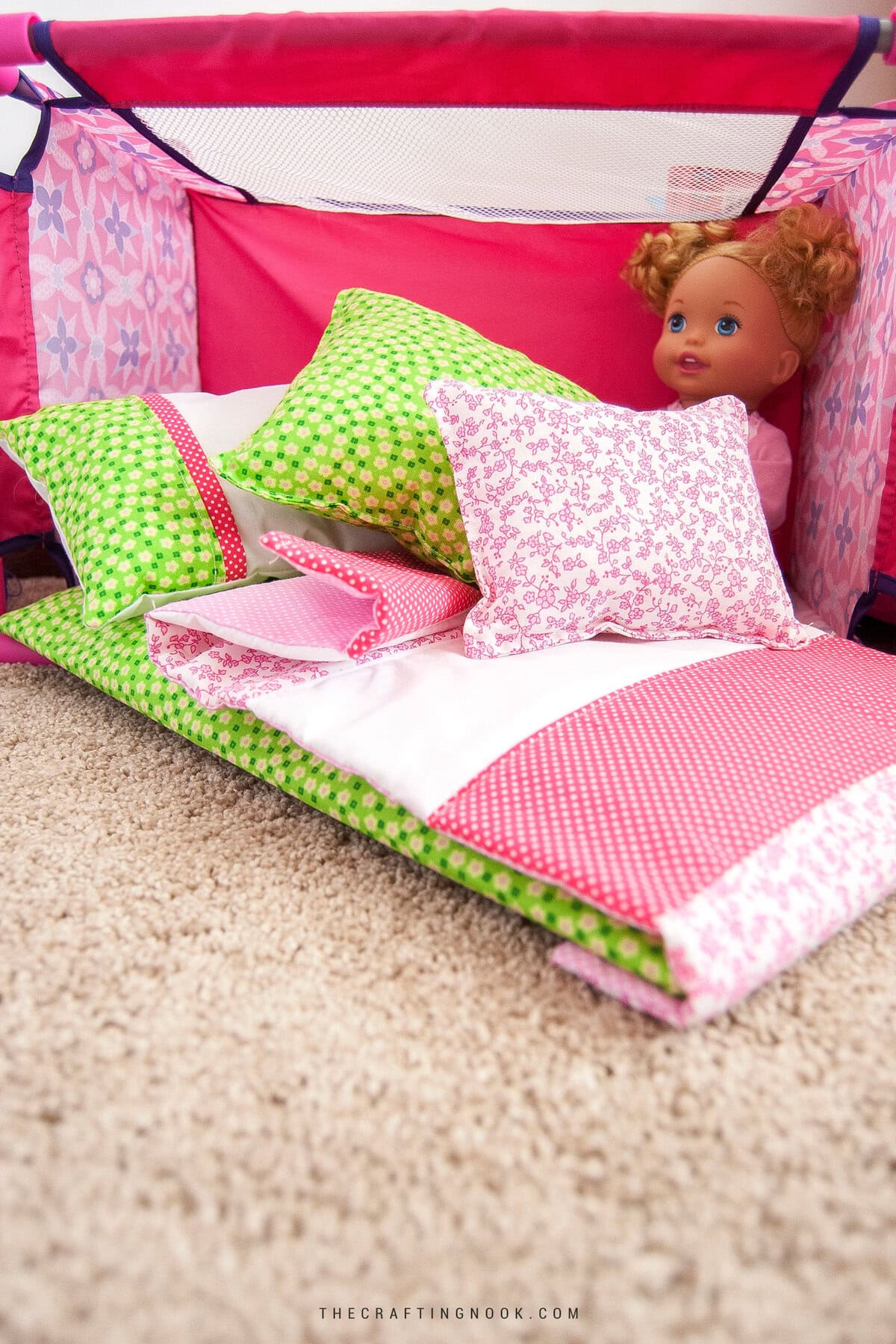 How to Make Doll Bedding Set for Cribs or Cradles. Feature Image. The bedding set on the floor next to the doll crib and a baby doll