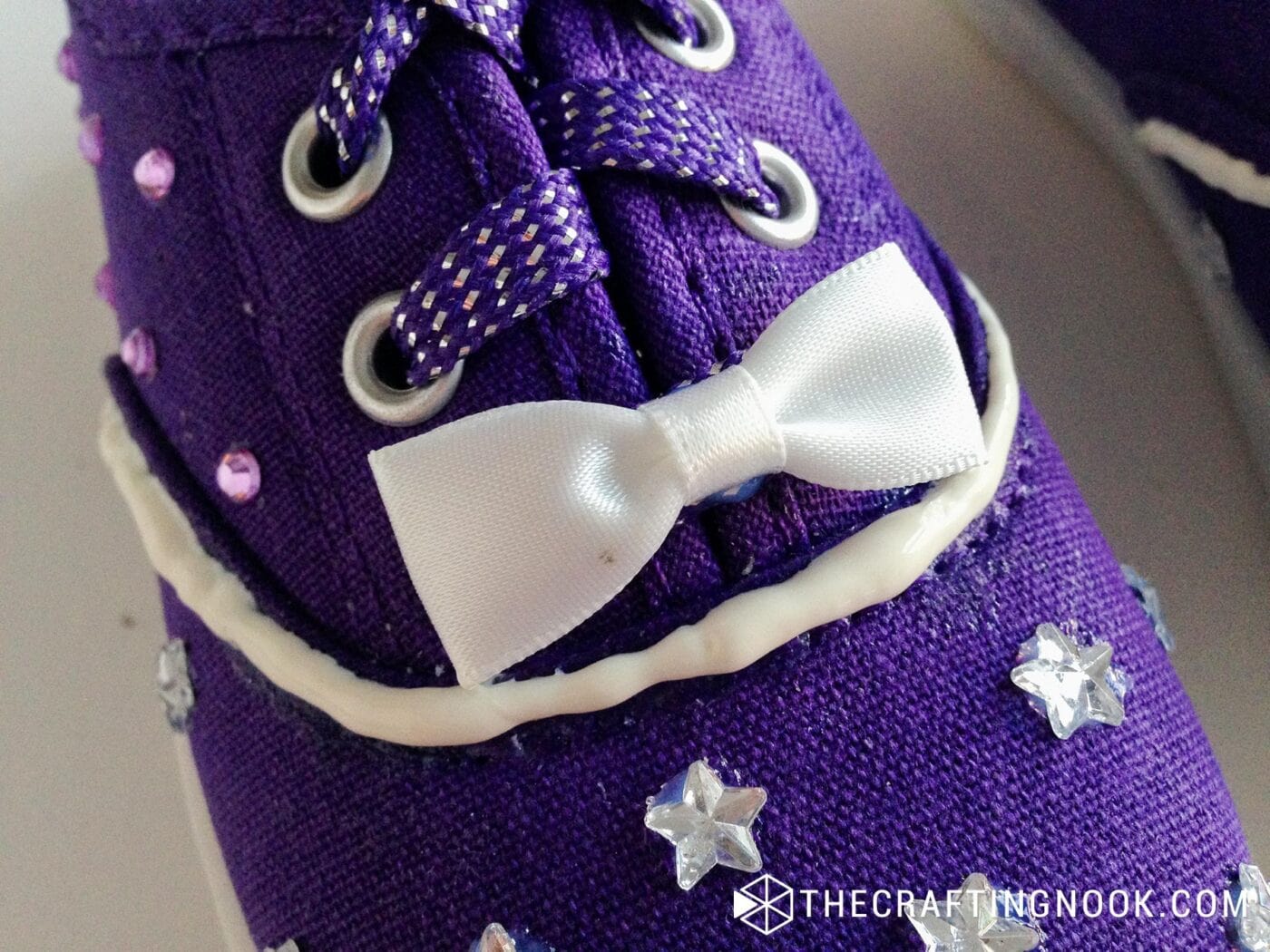 close up of one ribbon bow on shoe right on top of the cord where the cord holes begin