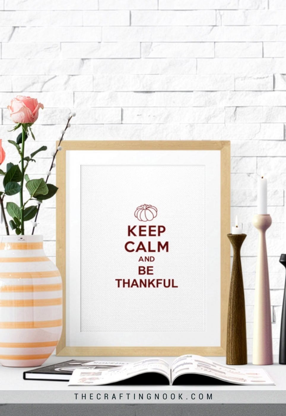 Free Keep Calm and Be Thankful Fall printable displayed in a wood frame on a decorated shelf with flowers, candles, and an open book.