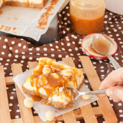 Delicious Salted Caramel Macadamia Nut Cheesecake Bars cutting with a spoon