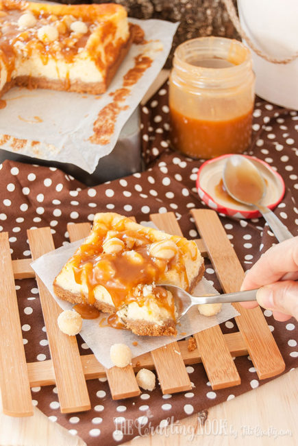 Delicious Salted Caramel Macadamia Nut Cheesecake Bars cutting with a spoon
