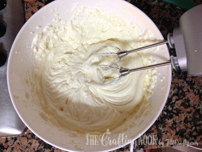 the cream cheese batter being mixed with the electric mixer