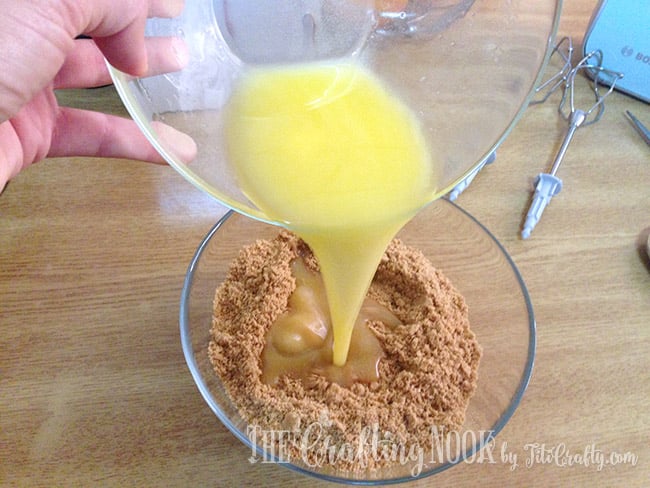 view of pouring melted butter over the crumbs