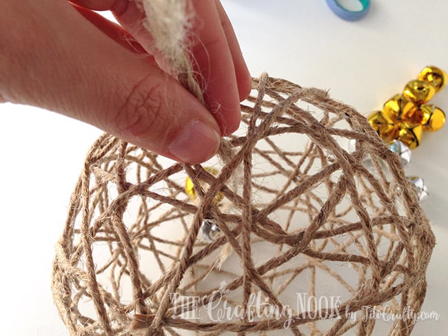 inserting the two bells into the twine ball