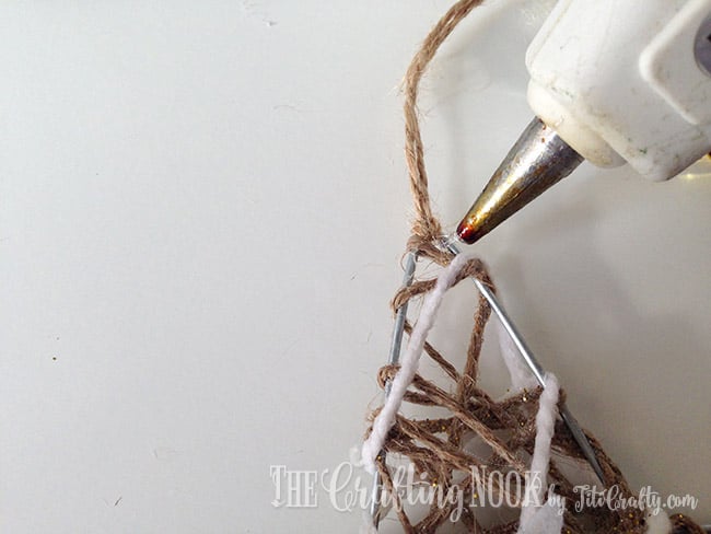 placing a dot of hot glue on the knot