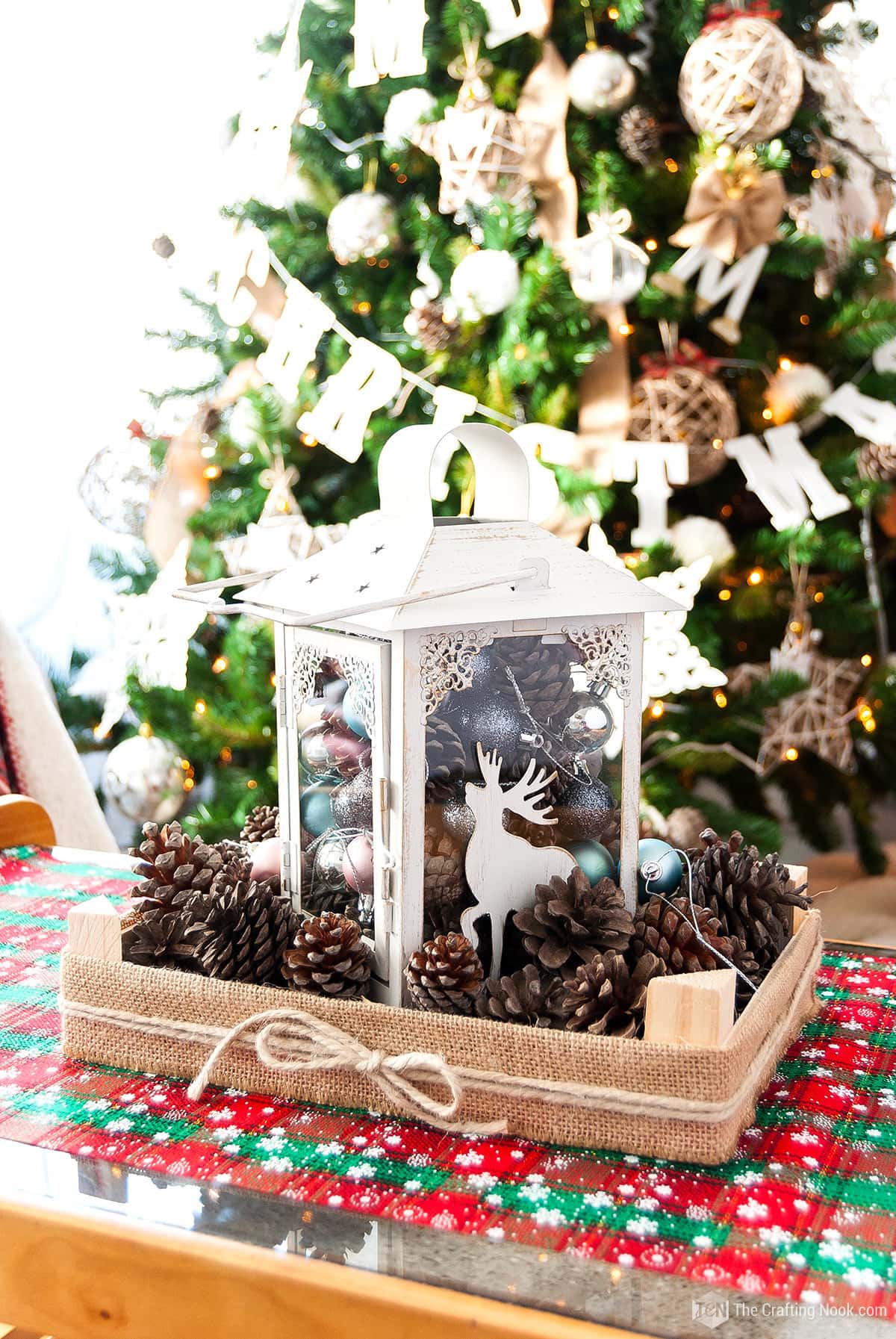 Rustic DIY Christmas Table Centerpiece with ornaments, pinecones and a lantern Upcycling a Fruit Crate with christmas tree on the background