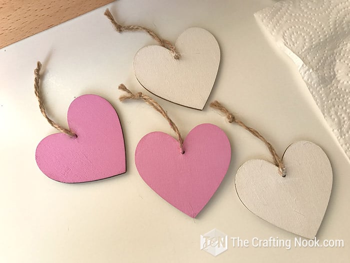 2 painted wooden hearts in pink and 2 in white