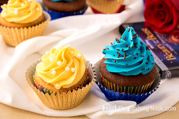 close view of the cupcakes already decorated with yellow and blue frosting to identify the filling
