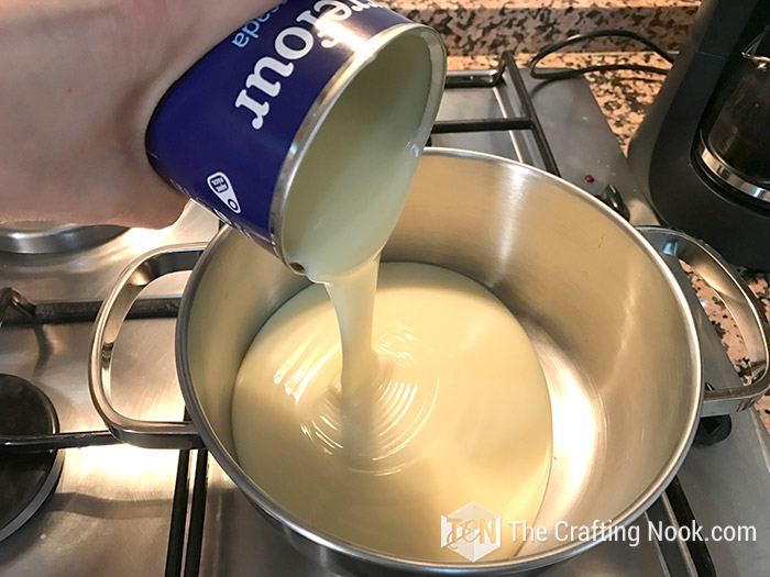 pouring condensed milk into a pot
